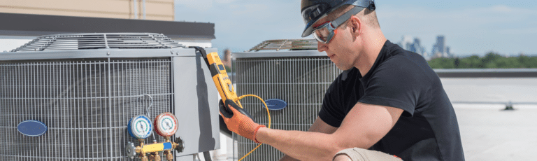 A worker performing HVAC maintenance while representing the importance of local marketing for HVAC companies.