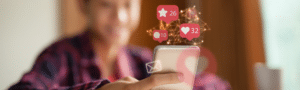 A person holding a smartphone displaying various social media icons, symbolizing social media engagement.