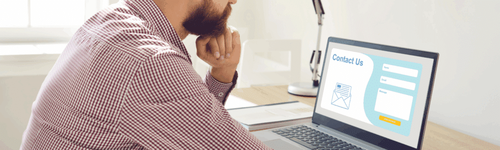 A man sitting at a desk, focused on a laptop, working on high-converting landing pages.