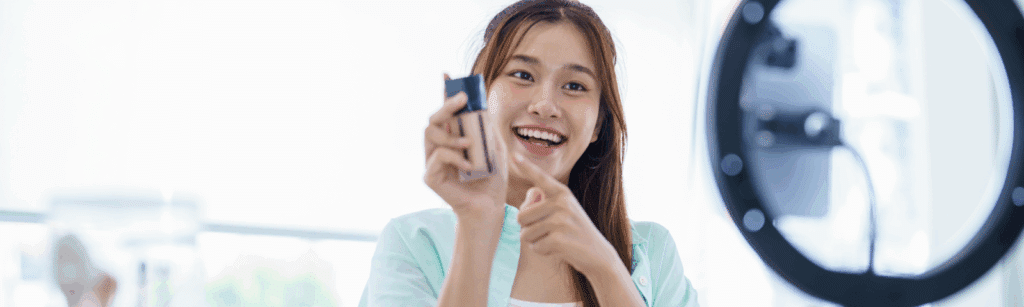 A smiling woman holds a product, representing eCommerce social media marketing engagement.