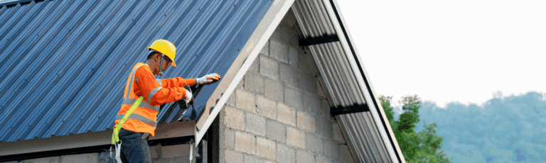 A man in an orange safety vest is working on a rooftop, focusing on roof repairs, representing the importance of Google Ads marketing in this industry.