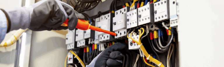 A person wearing gloves is holding an electric wire, representing the marketing of local electrical services.