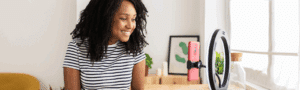 A woman uses a phone stand to film a video, showcasing user-generated content for social media.